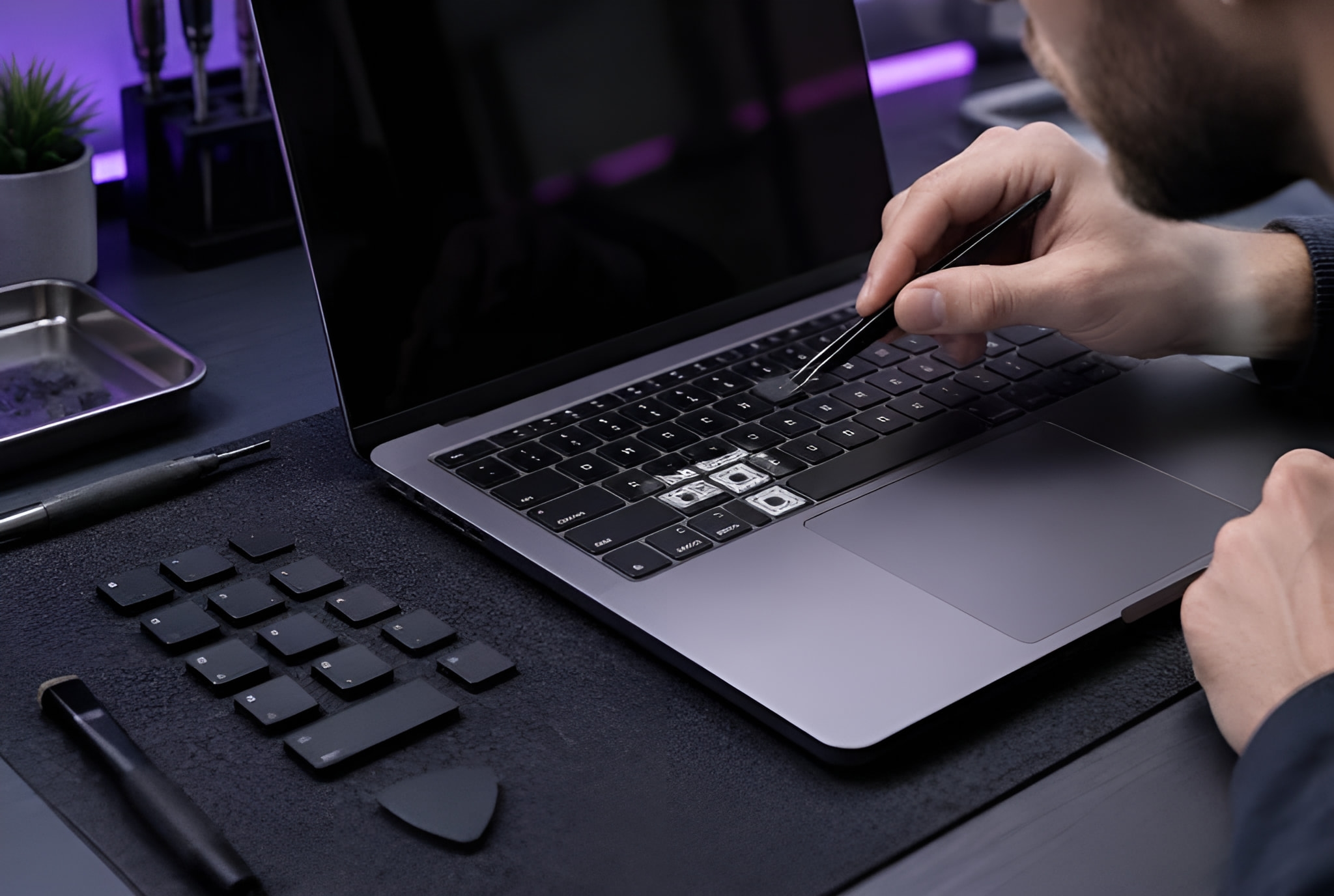 Hands working at a laptop keyboard on a desk